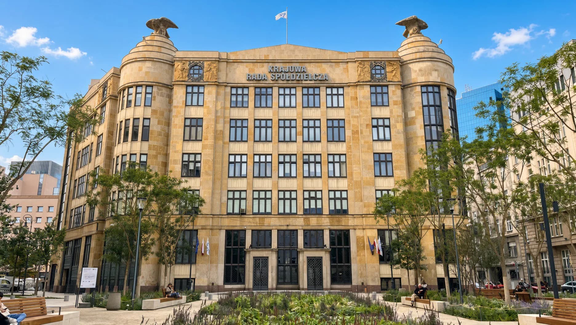 Fassade des Dom pod Orłami (Haus unter den Adlern) in der ul. Jasna 1 in Warschau: Sandsteingebäude mit Adlerskulpturen an den Ecken, Sitz von MS Trade und Mennica Skarbowa